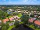 Stunning aerial view of a residential neighborhood featuring lush landscaping, lakes, and well-maintained homes with tile roofs at 6851 Bay Hill Dr, Lakewood Ranch, FL 34202
