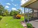 Beautifully landscaped backyard seen from screened patio with verdant lawn at 6851 Bay Hill Dr, Lakewood Ranch, FL 34202