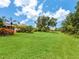 Expansive green backyard with lush landscaping, palm trees and other mature trees at 6851 Bay Hill Dr, Lakewood Ranch, FL 34202