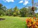 Spacious backyard with lush green lawn, mature trees and colorful landscaping at 6851 Bay Hill Dr, Lakewood Ranch, FL 34202