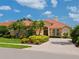 Beautiful home with a tile roof, arched windows, and lush landscaping at 6851 Bay Hill Dr, Lakewood Ranch, FL 34202