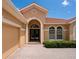 Inviting home exterior with a red tile roof, arched entryway, and manicured landscaping at 6851 Bay Hill Dr, Lakewood Ranch, FL 34202