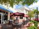 Outdoor dining area with tables and umbrellas, offering a relaxing atmosphere in a beautiful location at 6851 Bay Hill Dr, Lakewood Ranch, FL 34202