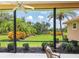 View of the lush landscaped backyard from the screened lanai with comfortable seating at 6851 Bay Hill Dr, Lakewood Ranch, FL 34202