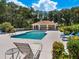 Inviting community pool area with plenty of lounge chairs, lush landscaping, and a cabana for shade and relaxation at 6851 Bay Hill Dr, Lakewood Ranch, FL 34202