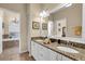 Elegant bathroom with double vanity, granite countertops, and a large mirror, offering a luxurious and functional space at 6908 Stoneywalk Ct, Bradenton, FL 34203