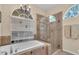Luxurious bathroom with soaking tub, glass-enclosed shower, and chandelier, offering a spa-like experience and elegant design at 6908 Stoneywalk Ct, Bradenton, FL 34203