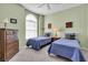 Charming bedroom with twin beds, arched window, dresser, and soft lighting, creating a cozy and inviting space at 6908 Stoneywalk Ct, Bradenton, FL 34203