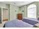 Comfortable bedroom with twin beds, arched window, dresser, and neutral color palette, perfect for relaxation and rest at 6908 Stoneywalk Ct, Bradenton, FL 34203