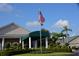 Inviting clubhouse entrance with an American flag, covered entryway, and well-manicured landscaping at 6908 Stoneywalk Ct, Bradenton, FL 34203