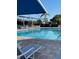 Relaxing community pool area with blue canopies, clear water, and comfortable lounge chairs at 6908 Stoneywalk Ct, Bradenton, FL 34203