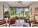 Bright sunroom with tile floor and golf course views, complete with a ceiling fan and comfortable seating at 6908 Stoneywalk Ct, Bradenton, FL 34203