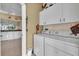 Convenient laundry room features washer, dryer, and ample overhead storage cabinets at 6908 Stoneywalk Ct, Bradenton, FL 34203