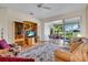 Bright living room with comfortable seating, entertainment center, and sliding glass doors to the lanai and golf course view at 6908 Stoneywalk Ct, Bradenton, FL 34203