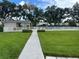 Community pool surrounded by lush green grass and mature trees, offering a relaxing atmosphere at 6908 Stoneywalk Ct, Bradenton, FL 34203