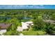 Stunning home on a lush lot with a lake view, featuring a large driveway, and beautiful mature trees at 7404 Weeping Willow Blvd, Sarasota, FL 34241