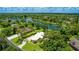 Gorgeous aerial view of a home on a lake surrounded by lush, mature trees in a serene neighborhood at 7404 Weeping Willow Blvd, Sarasota, FL 34241