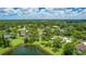 Overhead view of community featuring a serene lake, lush lawns, mature trees, and lovely homes at 7404 Weeping Willow Blvd, Sarasota, FL 34241