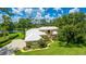 Luxury home nestled on the lake, features a pristine lawn, lush landscaping and a winding driveway at 7404 Weeping Willow Blvd, Sarasota, FL 34241