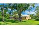 Spacious backyard featuring mature trees and a screened-in pool and lanai at 7404 Weeping Willow Blvd, Sarasota, FL 34241