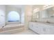 Bright bathroom with double sinks, garden tub, and tile flooring at 7404 Weeping Willow Blvd, Sarasota, FL 34241