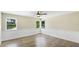 Bedroom with three windows, ceiling fan, and light hardwood flooring at 7404 Weeping Willow Blvd, Sarasota, FL 34241