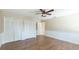 Spacious bedroom with two closets, ceiling fan, and light hardwood flooring at 7404 Weeping Willow Blvd, Sarasota, FL 34241