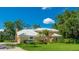 Beautiful home with a white tile roof, lush landscaping, and a spacious driveway, perfect for Gathering living at 7404 Weeping Willow Blvd, Sarasota, FL 34241