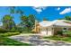 Home features a well-manicured lawn, a spacious driveway, and a two-car garage, close to the lake at 7404 Weeping Willow Blvd, Sarasota, FL 34241