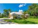 Beautiful home with a white tile roof, lush landscaping, and a spacious driveway, perfect for Gathering living at 7404 Weeping Willow Blvd, Sarasota, FL 34241