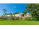 Stunning home featuring a well-manicured lawn and tropical landscaping, creating an inviting curb appeal at 7404 Weeping Willow Blvd, Sarasota, FL 34241