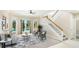 Bright living room with pool access, neutral tones, statement rug, and staircase at 7404 Weeping Willow Blvd, Sarasota, FL 34241