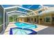 Spacious screened-in pool and spa area with brick pavers and view of the house at 7404 Weeping Willow Blvd, Sarasota, FL 34241