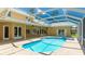 Large screened-in pool with a spa and a beautiful backyard view of the house at 7404 Weeping Willow Blvd, Sarasota, FL 34241
