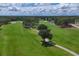 Overhead shot of the golf course showing expansive greens and sand traps surrounded by lush trees at 7866 Eagle Creek Dr # 7866, Sarasota, FL 34243