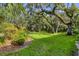Expansive backyard featuring a lush lawn, mature trees, and beautiful landscaping at 7866 Eagle Creek Dr # 7866, Sarasota, FL 34243