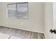 This bedroom has wood-look floors, a window with blinds, and a fresh coat of paint at 7866 Eagle Creek Dr # 7866, Sarasota, FL 34243