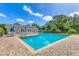 Community pool with chairs, tables, umbrellas, and lounge seating on brick surface with nearby building at 7866 Eagle Creek Dr # 7866, Sarasota, FL 34243