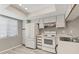 This bright kitchen features white cabinets, wood trim, and stainless sink and appliances at 7866 Eagle Creek Dr # 7866, Sarasota, FL 34243
