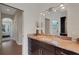 Bathroom featuring granite countertops, wood cabinetry, a decorative vase, and access to the bedroom and hallway at 8102 Waterview Blvd, Lakewood Ranch, FL 34202