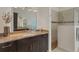 Spacious bathroom featuring natural stone countertops, dark brown cabinetry and a tiled shower at 8102 Waterview Blvd, Lakewood Ranch, FL 34202