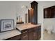 Bathroom featuring natural stone countertop, dark brown cabinetry and a lighted mirror at 8102 Waterview Blvd, Lakewood Ranch, FL 34202