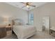 Bedroom featuring neutral tones, a ceiling fan, shuttered windows, and elegant decor creating a serene and inviting atmosphere at 8102 Waterview Blvd, Lakewood Ranch, FL 34202