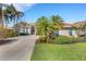 A beautiful one-story home with a terracotta roof, lush landscaping, and a large driveway at 8102 Waterview Blvd, Lakewood Ranch, FL 34202