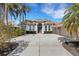 Charming single-story home with a spacious driveway, lush landscaping, and a terracotta tile roof at 8102 Waterview Blvd, Lakewood Ranch, FL 34202