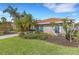 Lush front yard with tropical plants and well-manicured landscaping enhances this one-story residence's curb appeal at 8102 Waterview Blvd, Lakewood Ranch, FL 34202