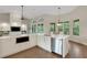 Kitchen features modern appliances, white cabinetry, quartz countertops, and hardwood floors at 8102 Waterview Blvd, Lakewood Ranch, FL 34202