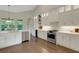 Bright, open kitchen with white cabinets, stainless steel appliances, and hardwood floors at 8102 Waterview Blvd, Lakewood Ranch, FL 34202