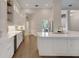 Bright kitchen with hardwood floors, white cabinets, a large island, and stainless-steel appliances at 8102 Waterview Blvd, Lakewood Ranch, FL 34202