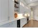 White kitchen with stainless steel appliances, a wine fridge, and open shelving with decor at 8102 Waterview Blvd, Lakewood Ranch, FL 34202